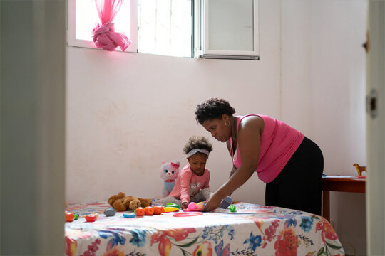 Black Mom With Her Daughter On The Bedroom At Home.