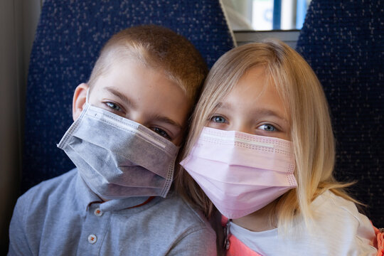 Kids on a train wearing masks.