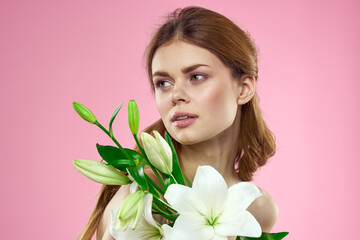 Beautiful woman with flowers on pink background makeup portrait model