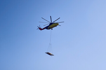 The world's largest cargo helicopter hovers overhead. Bottom view.The world's largest cargo helicopter transports cargo on a wire rope. Bottom view