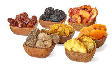 Dried pineapple, peach, prune, apricot, fig, dates, raisins in the bowls isolated on white background