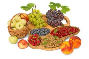 Still life with fruits - apples, grapes, raspberries, currants, peaches, blueberries in wood trays and basket isolated on white