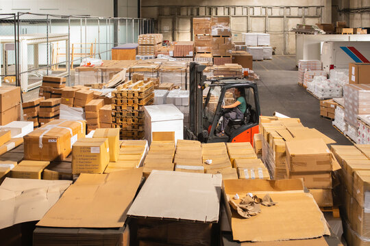 The worker transports freight using a forklift