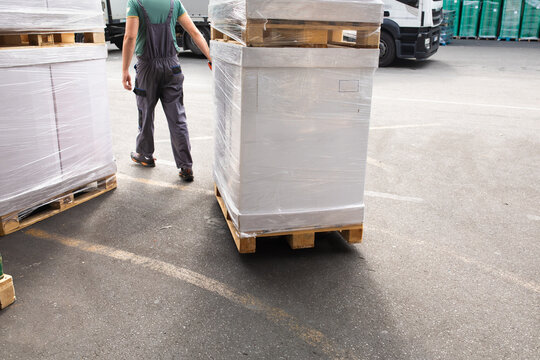 One man operates the pallet jack in a warehouse full of shipping goods