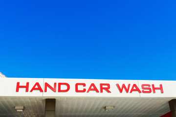 Hand Car Wash sign on canopy structure of facility used to clean motor vehicles.