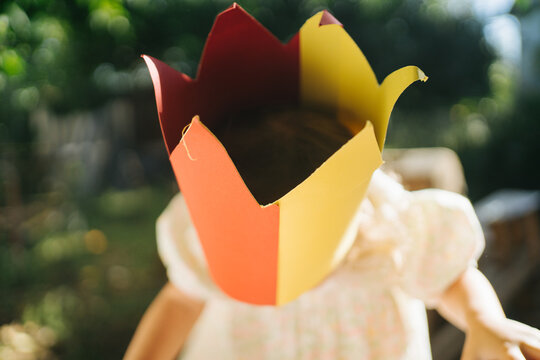 Cute little girl in paper crown playing outside