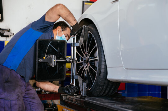 Adult mechanic using device in tire of car