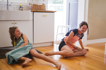 Two sisters having fun baking cookies together in a modern kitch