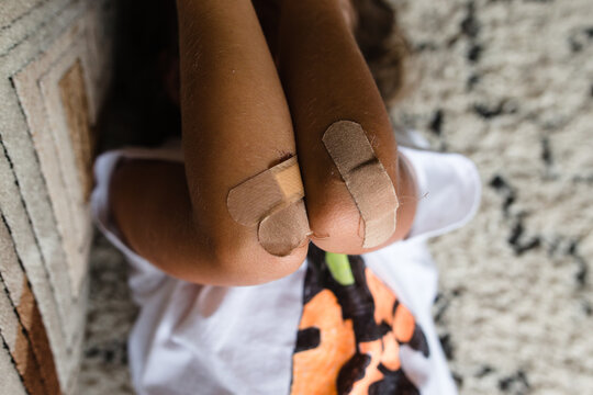 child with bandages on scrapes