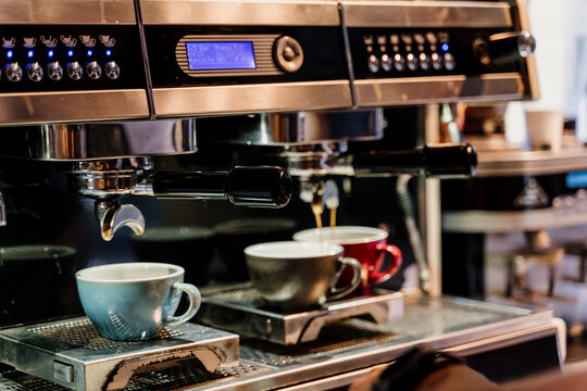 Detail of a professional coffe machine dripping coffe into an empty cup in a cafeteria