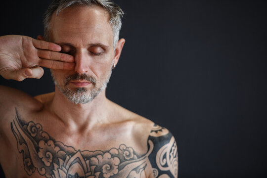 Relaxed bearded man meditating with closed eyes