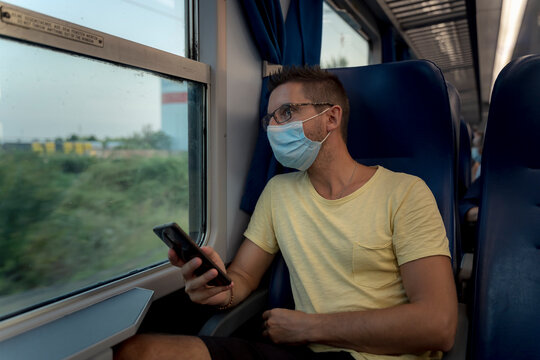 A man traveling by train and wearing a surgical mask during the Covid-19 crisis