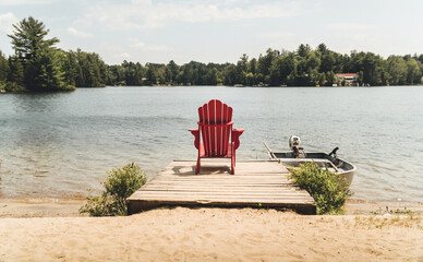 Empty red chair on a lake during summer