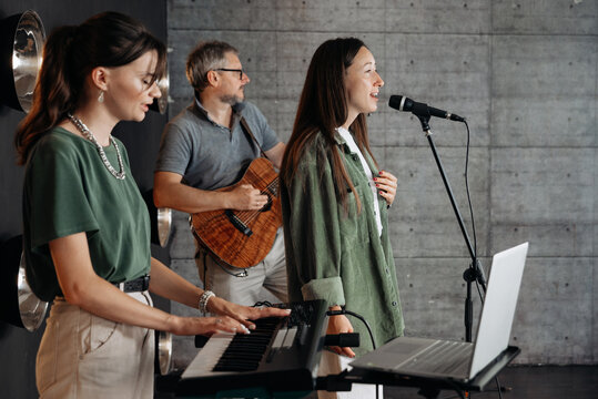Music band singing and playing instruments in studio