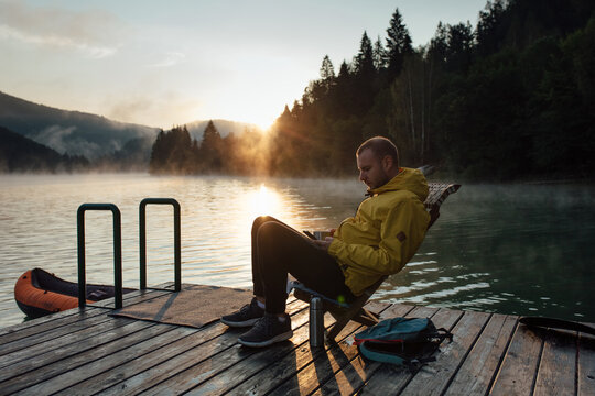 Man using a phone by the lake