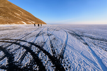 Lake Baikal in winter, the lake's surface is frozen solid that strong enough for a vehicle to pass. Tire tracks on the ice