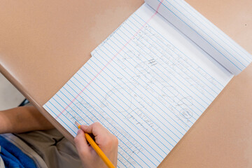 Boy's hands taking notes in a class