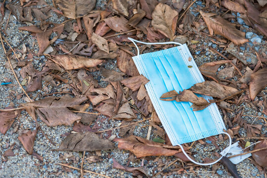 protective medical mask is lying like garbage on the asphalt, the used mask was crushed and thrown away, medical waste, photos on the topic of ecology