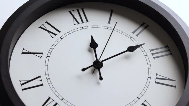 Time lapse movie. Large white wall clock Set the time for 12.00 o'clock. The red minute hand keeps running. Roman numerals