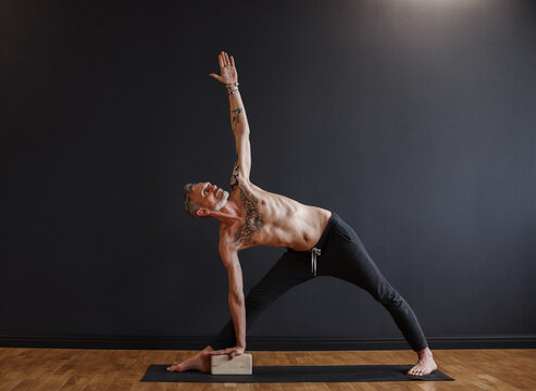 Flexible mature man practicing triangle pose