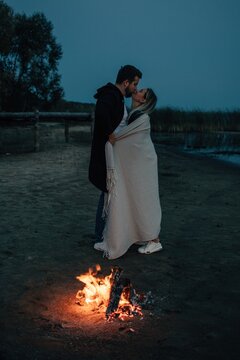 Couple kissing near bonfire