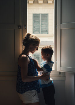 Mother and son sharing a moment by the room window.
