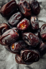 close up sticky chewy dried dates on coarse burlap cloth. traditional oriental sweets. healthy natural snack. selective focus