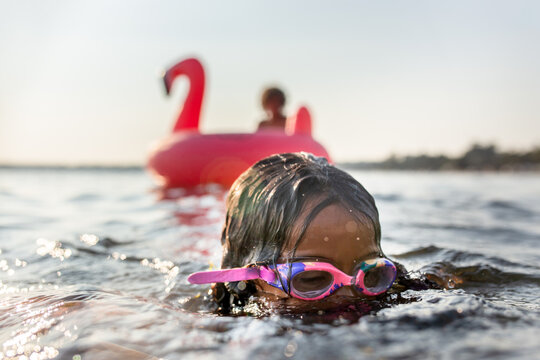 Girl in goggles emerges from underwater