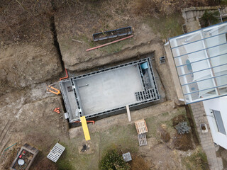 Drones aerial photo of a construction site of a pool, formwork concrete blocks already finished and bricked up with construction adhesive, steps already prepared and ready for concrete filling