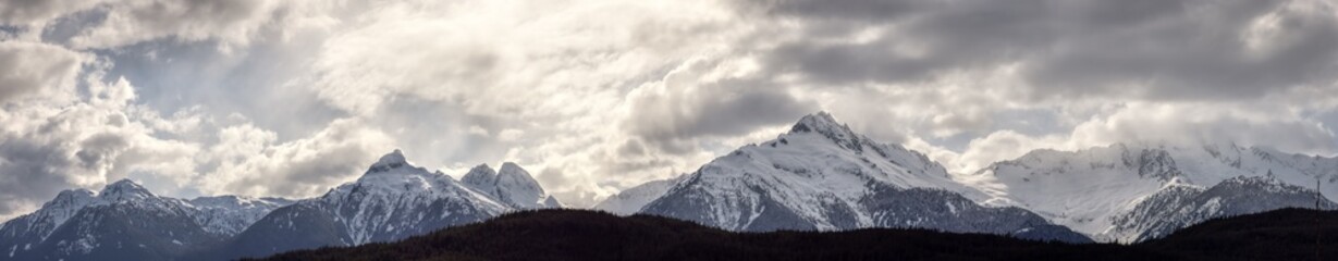 Obraz premium Panoramic Canadian Mountain Landscape View during a cloudy winter day. Taken in Tantalus Lookout near Squamish and Whistler, North of Vancouver, BC, Canada. Background Panorama