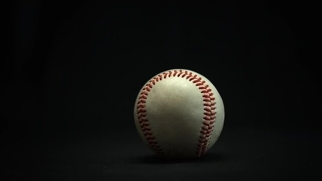 Changing an old baseball for a new baseball. Black Background