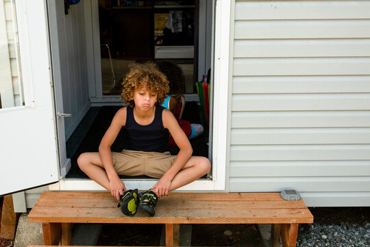 Curly haired boy pouts on steps