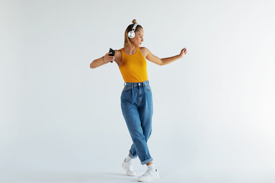 Stylish female listening to music and dancing