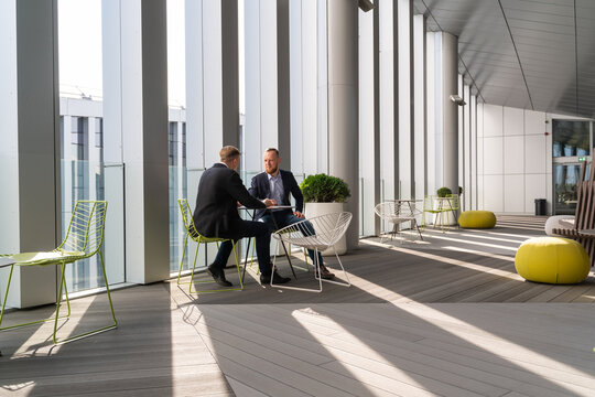 Businessmen Having Conversation At Office Terrace