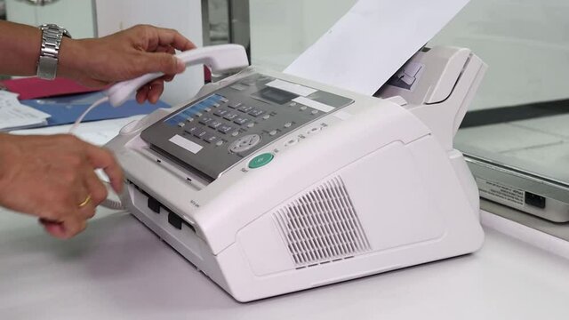 hand man are using a fax machine in the office, equipment for data transmission