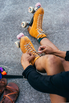 Overshoulder view of an unrecognizable african american woman tying laces on rollerskates