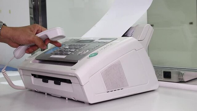hand man are using a fax machine in the office, equipment for data transmission