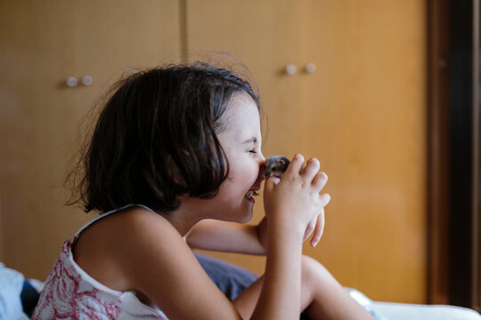Kid sitting on bed playing with hamster