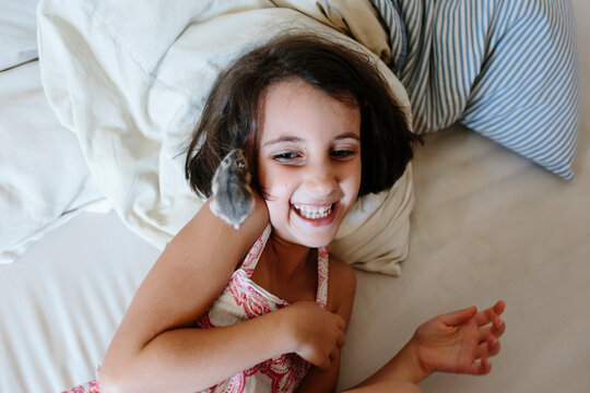 Kid laying on bed playing with hamster