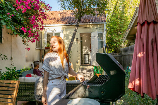 Woman Flips Hotdog At Grill