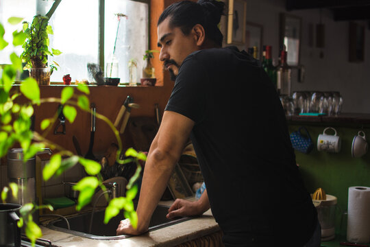 Man leaning on a kitchen sink