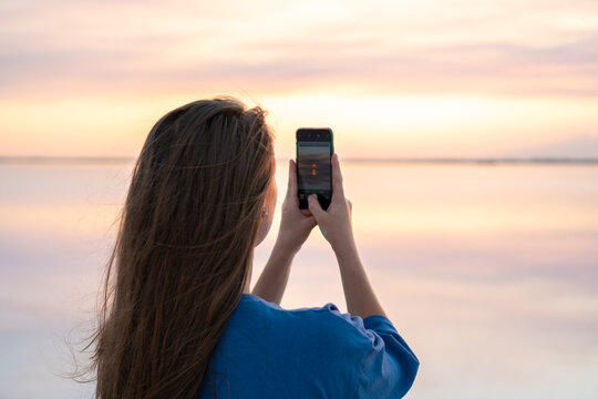 Traveller Woman taking a vertical photo of sunset