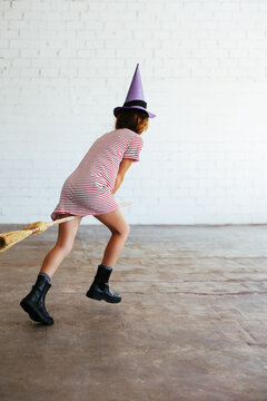 Unrecognizable witch running and flying broom