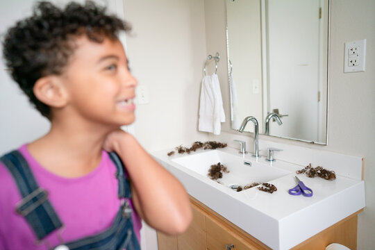 Out Of Focus Girl With Shirt Hair And Sink With Cut Hair