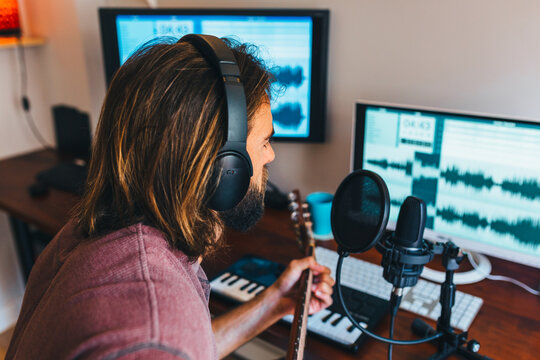Young man recording music at home music studio