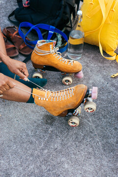 Unrecognizable African American woman tying shoe laces on her rollerskates