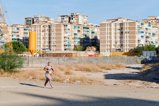 Plus size woman jogging through an empty city lot
