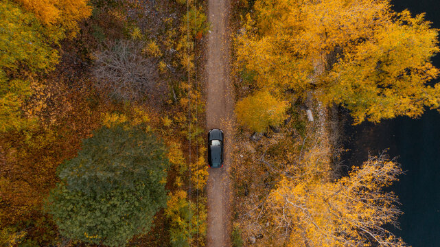 Black SUV car on a gravel road. Flat lay drone shot