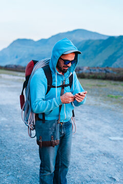 Male climber using smartphone in countryside
