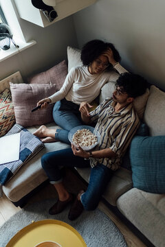Young Couple, Flatmates Watching Television at Home